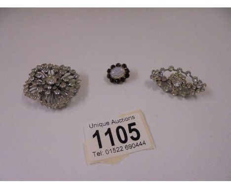 An antique opal/red stones brooch and two diamonte brooches.