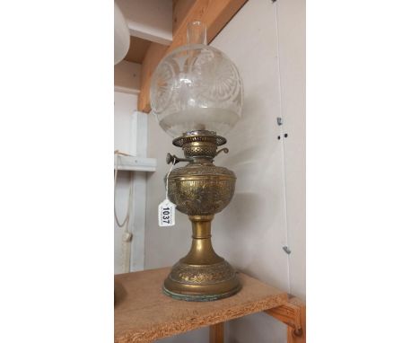 A Victorian oil lamp with embossed brass base and original etched shade. COLLECT ONLY.