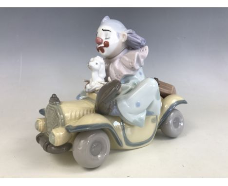 A Lladro figurine of a young clown in car with puppy