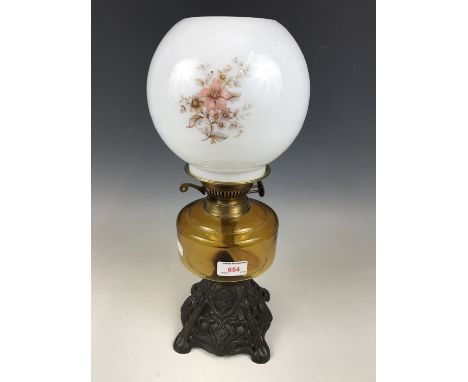 A cast-metal and amber glass oil lamp 