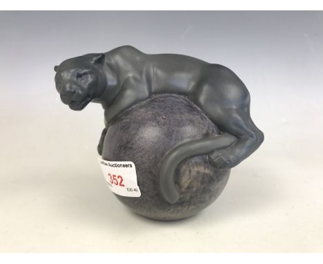 A Lladro figurine of a panther resting on a globe