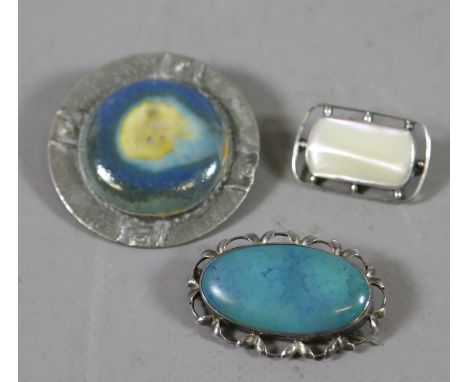 Three Arts and Craft brooches to include a Ruskin tablet example, another similar and a mother of pearl example.