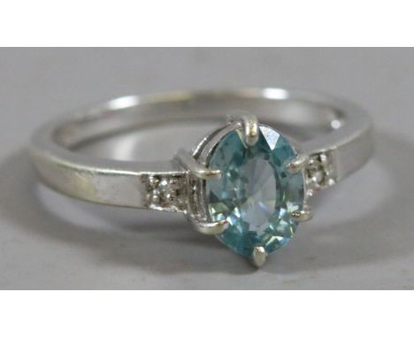 A 9ct white gold ring set with a faceted ovoid blue topaz stone and diamond set shoulders, size N.