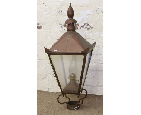 A large Victorian copper lantern with pointed finial and raised on scrolling brackets.