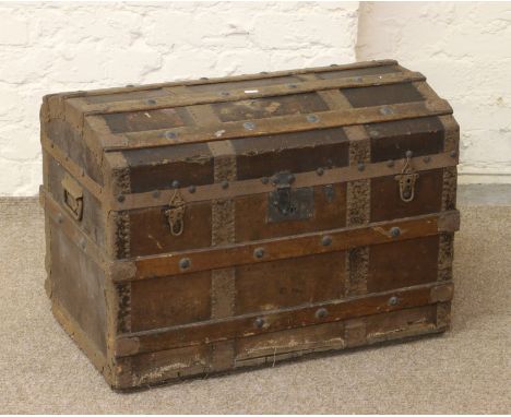A dome top metal bound travel trunk.