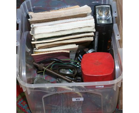 A box of vintage car spares and tools along with manuals and handbooks.