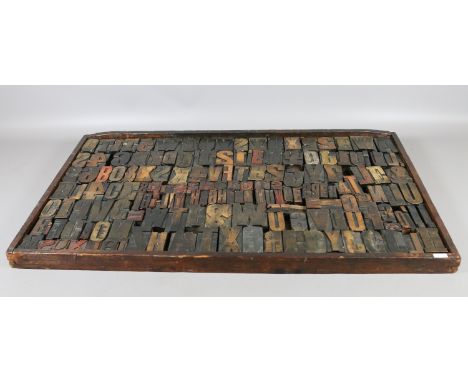 A printers vintage wooden typecase and assortment of carved wooden letters.