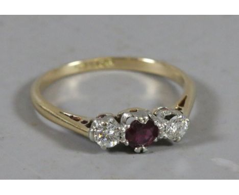 A ladies 18 carat gold, ruby and diamond three stone ring. UK size K.