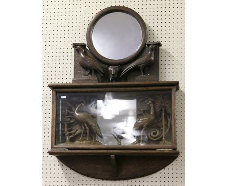 A shelf mounted carved oak hall mirror over mirrored display of animals and birds.