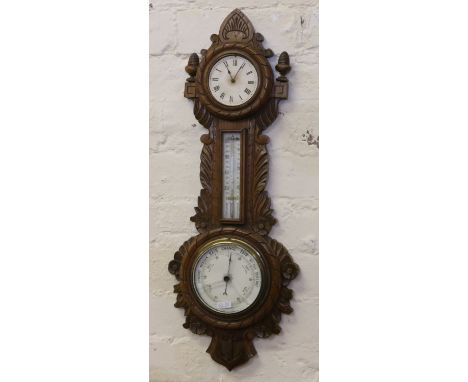 A Victorian carved oak wall barometer incorporating a time piece and a thermometer. Ornamented with scrolling foliage, flower