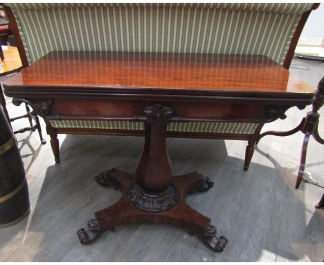 A 19th Century mahogany folding card table on a panelled baluster column with concave rectangular plateau and scrolled feet, 