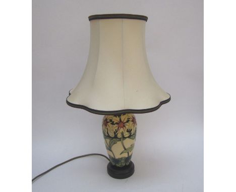 A Moorcroft table lamp base, cream ground with floral design, 48cm tall with shade