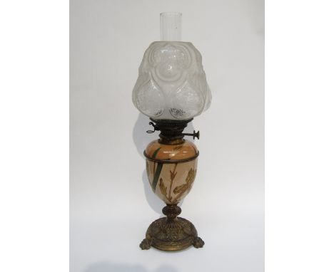 An Art Nouveau ceramic oil lamp on brass claw feet with Hinks No.2 Duplex ceramic button, decorated with Iris flowers (a/f sm