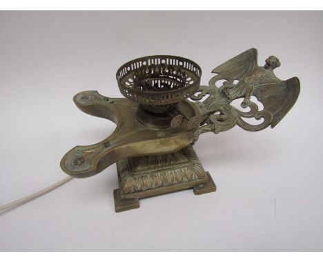 An unusual brass lamp base in the form of a twin Aladdin lamp with bat embellishment, converted to electricity