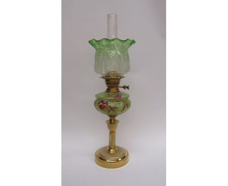 A Victorian oil lamp, green glass shade and reservoir, handpainted design of flowers, fluted brass support and base