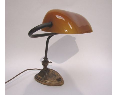 An Art Deco style brass bankers lamp with amber shade