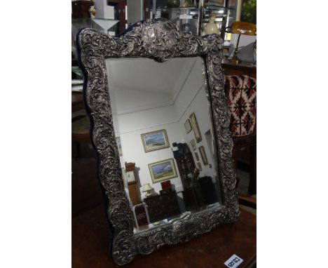 A Victorian silver easel-back mirror, all-over scrolled foliage with figural relief, bevelled glass, 47.5cm tall