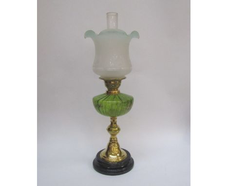 A Victorian oil lamp, green glass reservoir with handpainted foliage and floral sprays, brass support to base