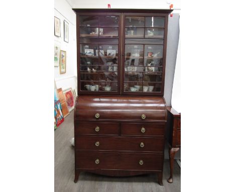 A George III mahogany secretaire cabinet astragal glazed top over barrel front opening to reveal writing surface and fitted i