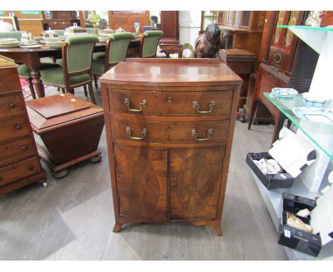 A 20th Century mahogany reproduction bow front cabinet of two drawers over a cupboard, raised upon swept bracket feet, 80cm x