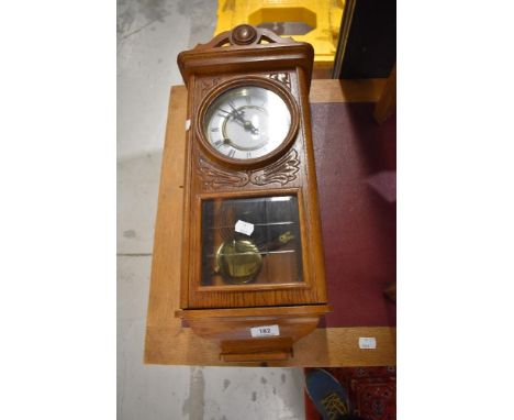 A vintage oak wall clock of small proportions, height 54cm