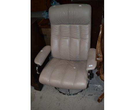 A vintage chrome and cream swivel easy chair with recline action