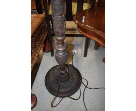 A heavily carved standard lamp , having vine decoration