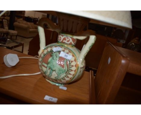 An Italian glazed pottery lamp , having three handle and painted mythical creature decoration