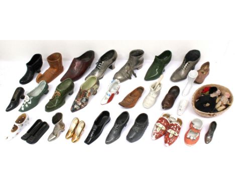 A collection of ornamental and collectors shoes to include pin cushions, treen shoes, metal and ceramic along with bisque dol