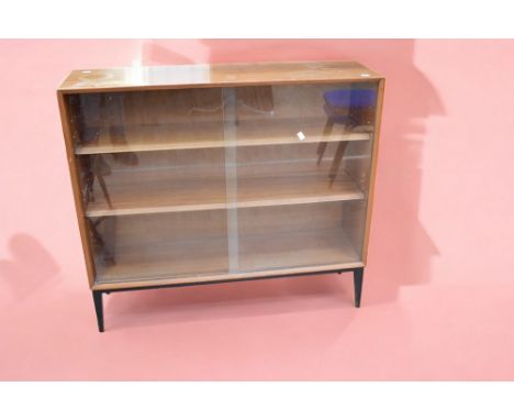 A 1960s teak cabinet with two glazed sliding doors and central internal shelf.