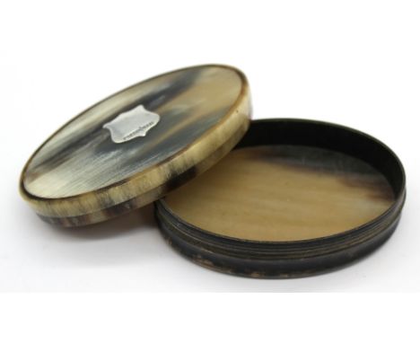 A late 19th century oval shaped horn lidded box, with blank silver shield shaped cartouche; 7.5cm wide