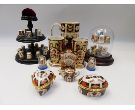A collection of Royal Crown Derby thimbles with stands, millennium mug, miniatures, Stafford imari trinket boxes, Lynton posi
