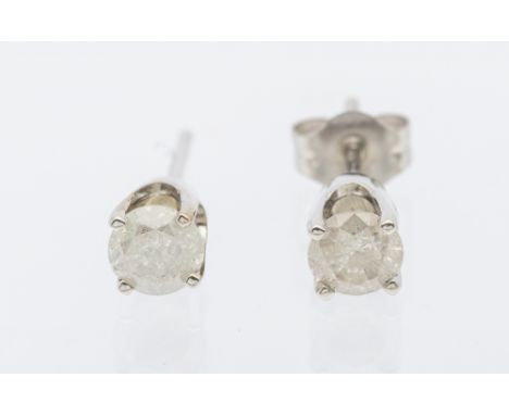 A pair of diamond solitaire white metal earrings, comprising claw set round brilliant diamonds, total diamond weight approx 0