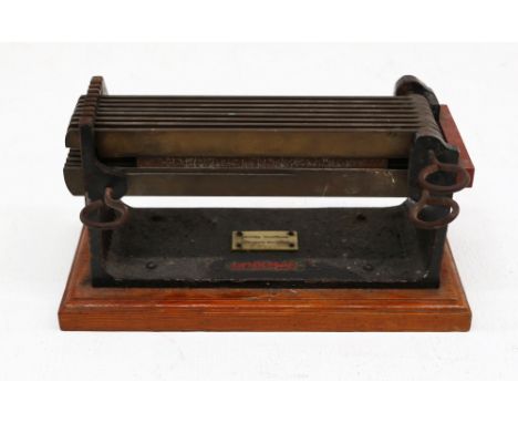 A 20th century Lister Brothers of Manchester brass and iron silk weaving tool; raised on rectangular plinth base; 25cm wide