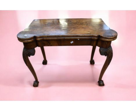 A George III mahogany ornate card/games table in the Chippendale style, standing on cabriole legs, with ball and claw feet.