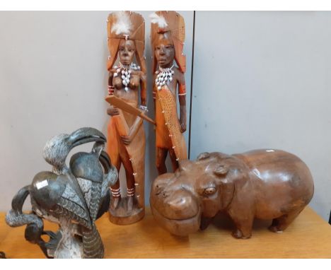 A carved treen model of a hippopotamus, 21cm high x 45cm wide together with a stone model of long beaked birds and two Africa