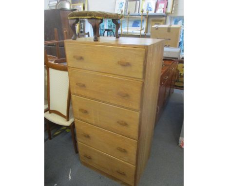 A light wood chest of five graduated drawers on plinth base 137cm x 69cm x 46cm, with an early 20th century stool having butt