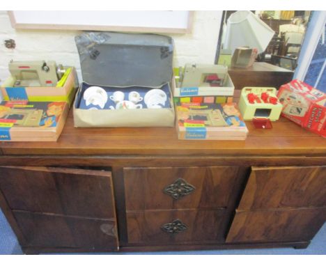 Two boxed Vulcan child's sewing machines, a child's toy tin plate kitchen stove model no. 298 with pots and pans, and a boxed