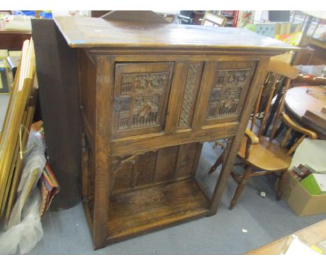 An early 20th century oak side cabinet having a stepped cornice, two carved doors and large open shelf below, 133cm h x 116cm