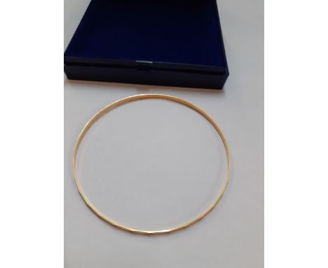 An 18ct gold bangle with faceted decoration, 3.9g 