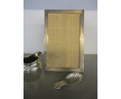 A mixed lot of silver items to include a Goldsmiths and Silversmiths silver framed desk calendar, London 1932, an early 20th 