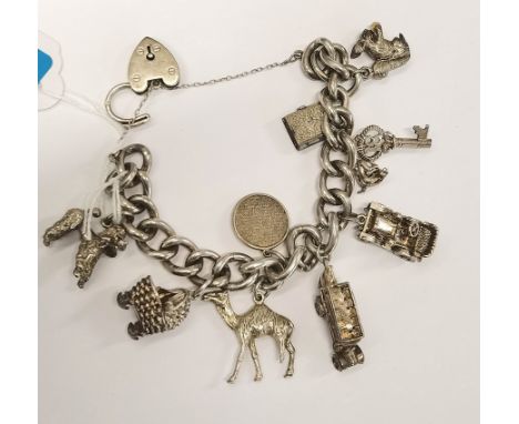 A silver charm bracelet with heart-shaped lock catch, and 9 novelty charms including a charabanc and vintage car Location: Ca