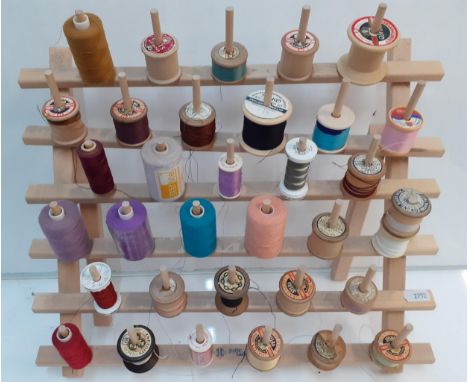 A collection of vintage wooden and later cotton reels to include Sylko, Dewhurst and Coats on a treen cotton reel stand toget