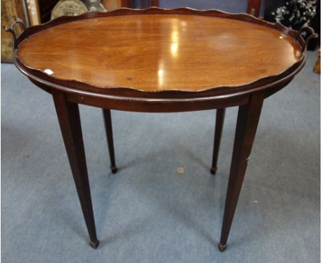 AN EDWARDIAN MAHOGANY OVAL TRAY TOP TABLE, with brass handles, 80cm wide