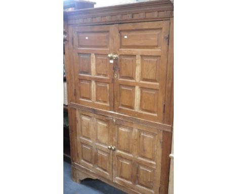 A 19TH CENTURY CONTINENTAL STRIPPED PINE PRESS CUPBOARD, with four panelled doors within a reeded frame and architectural cor