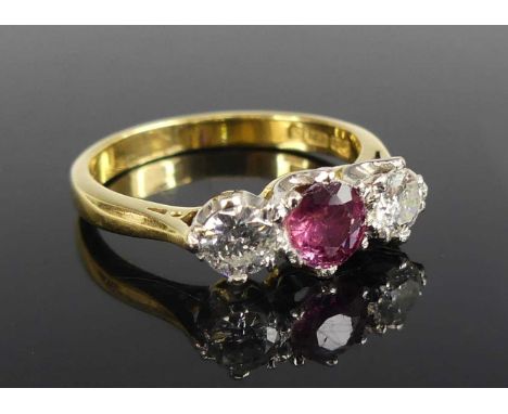 An 18ct yellow and white gold, pink tourmaline and diamond three-stone ring, featuring a round pink tourmaline with a round b