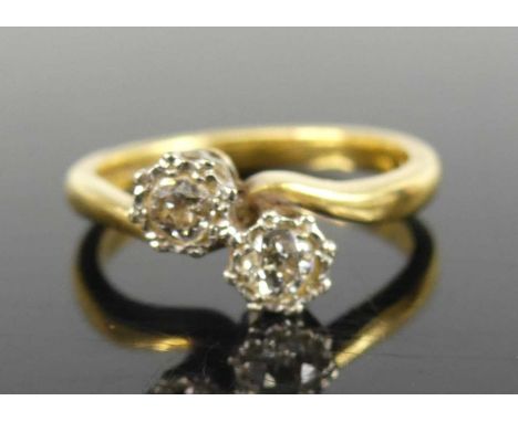 An 18ct gold diamond crossover ring arranged as two illusion set round cut diamonds, each weighing approx 0.15ct, 4.9g, size 