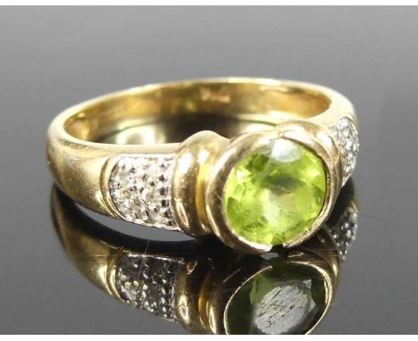 A 9ct gold peridot and diamond point set dress ring, the bezel set round cut peridot weighing approx 0.8ct, the shoulders bei