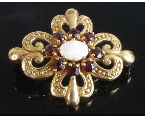 A 9ct yellow gold, opal and garnet Celtic style brooch, having a centre cluster of an oval cabochon opal and eight round garn