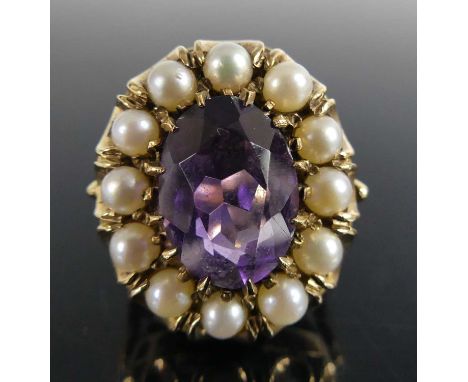 A yellow metal amethyst and pearl oval cluster ring comprising a centre oval facetted amethyst within a border of twelve 8mm 